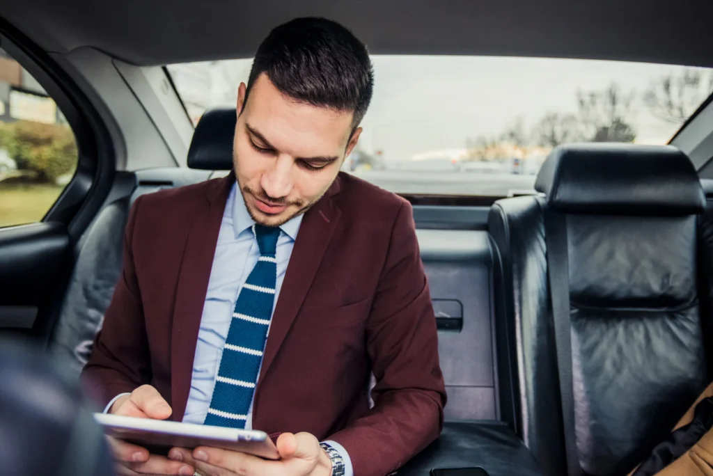Business Passenger using a tablet in the back seat of a Seattle limo service vehicle